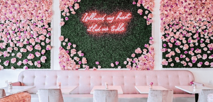 A flower wall and a blush pink couch at one of the most Instagrammable restaurants in Las Vegas