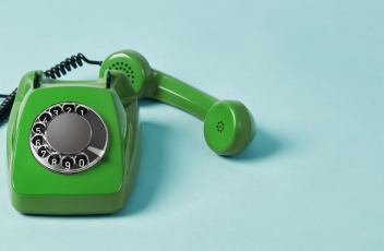 A green retro phone against a blue background