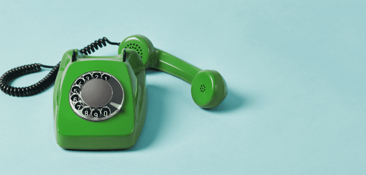 A green retro phone against a blue background