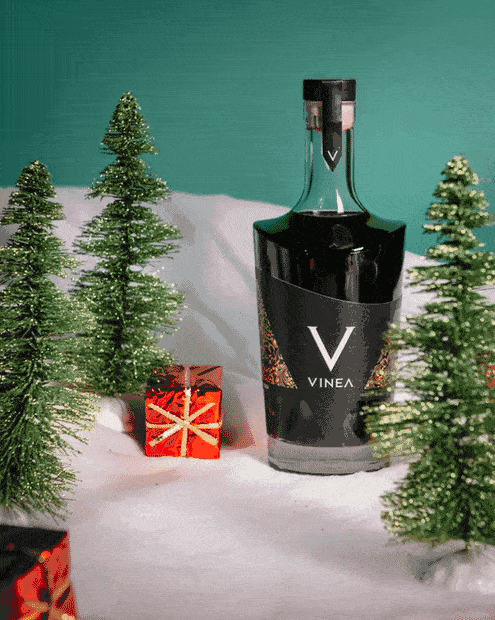 christmas themed stop motion of a cocktail sliding through a miniature winter scene with snow and christmas trees