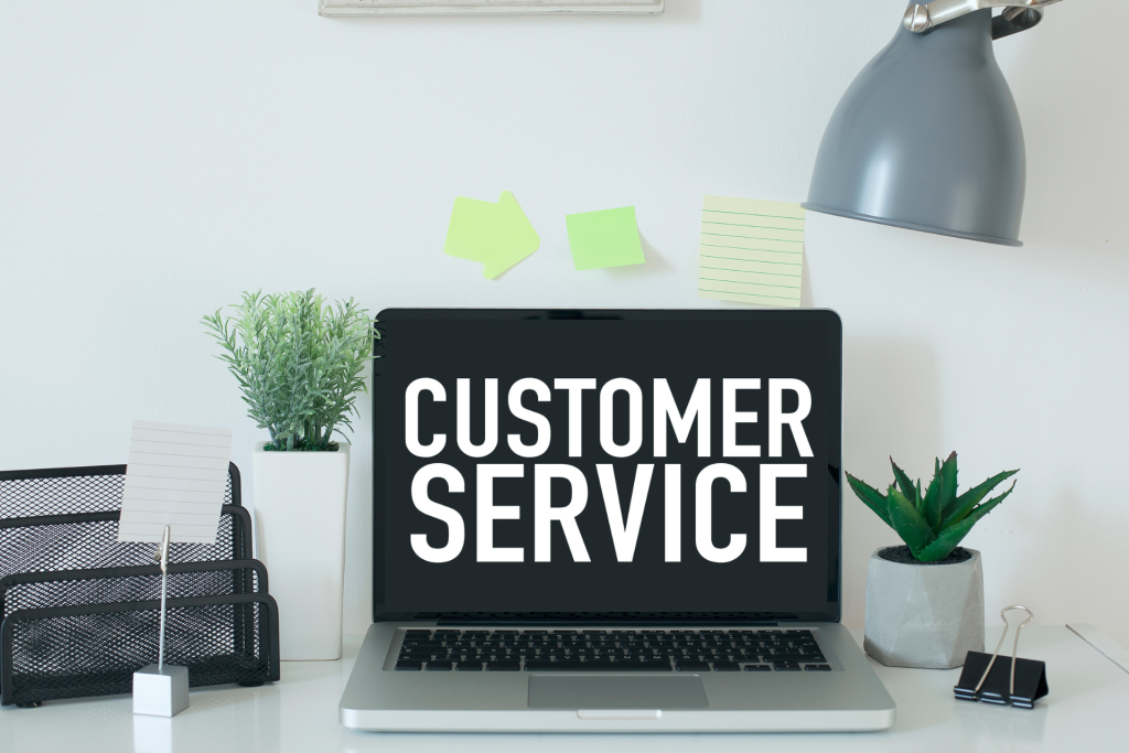 The words “customer service” on a laptop screen on a desk
