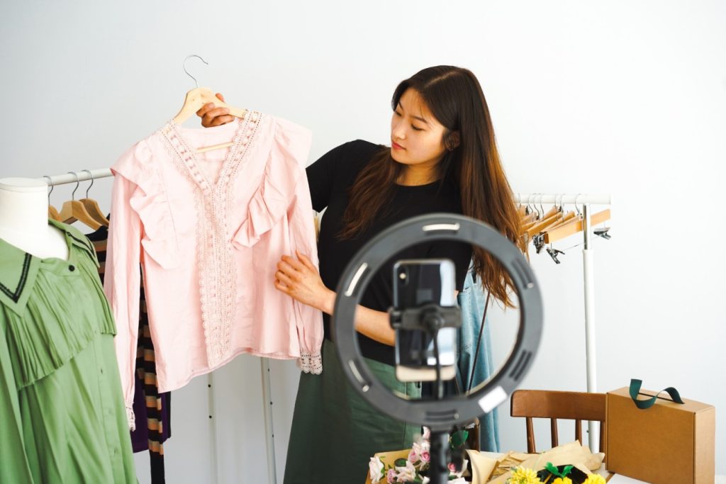 A woman livestream selling articles of clothing