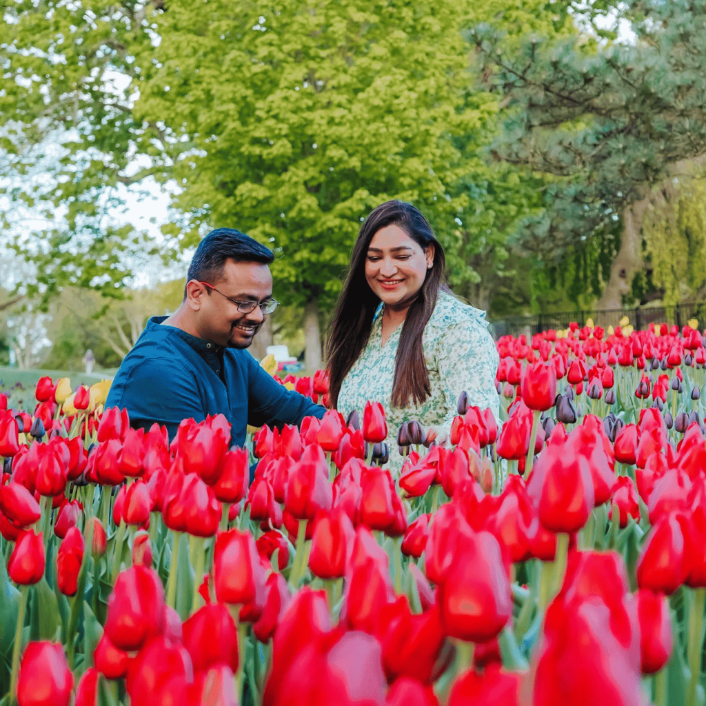 Saumya and Vishu in a field of red tulips