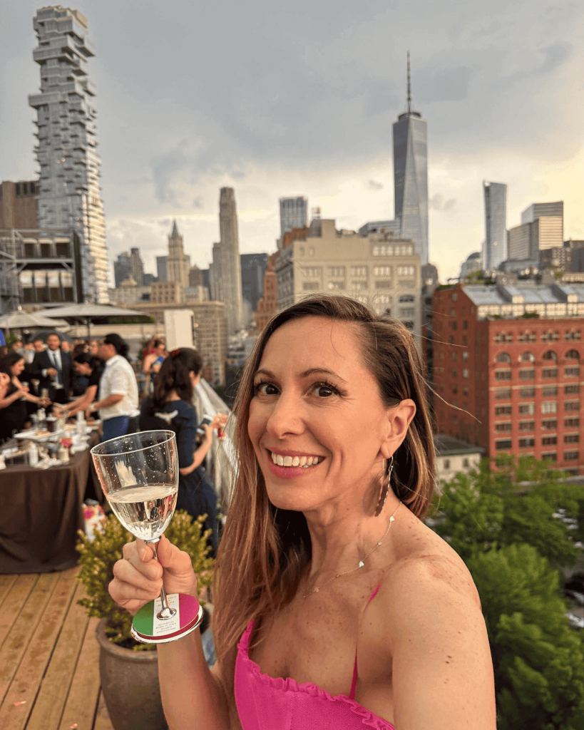 A close-up of Laura Giromini with a drink on a rooftop patio